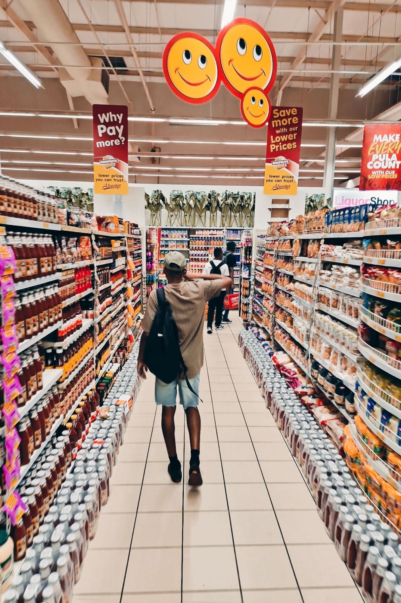 A shopper walking down a busy supermarket aisle