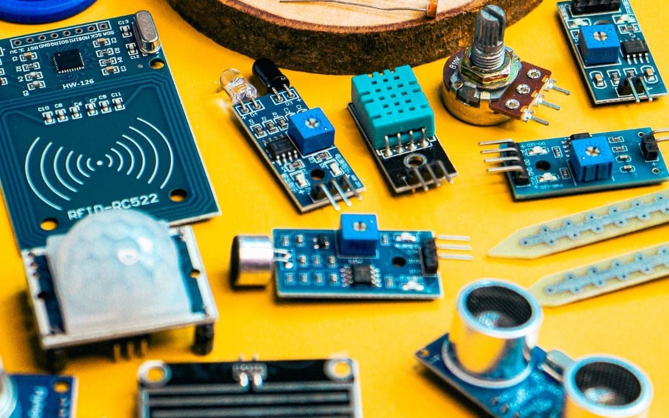 A kit of sensors and modules laid out on a yellow bench