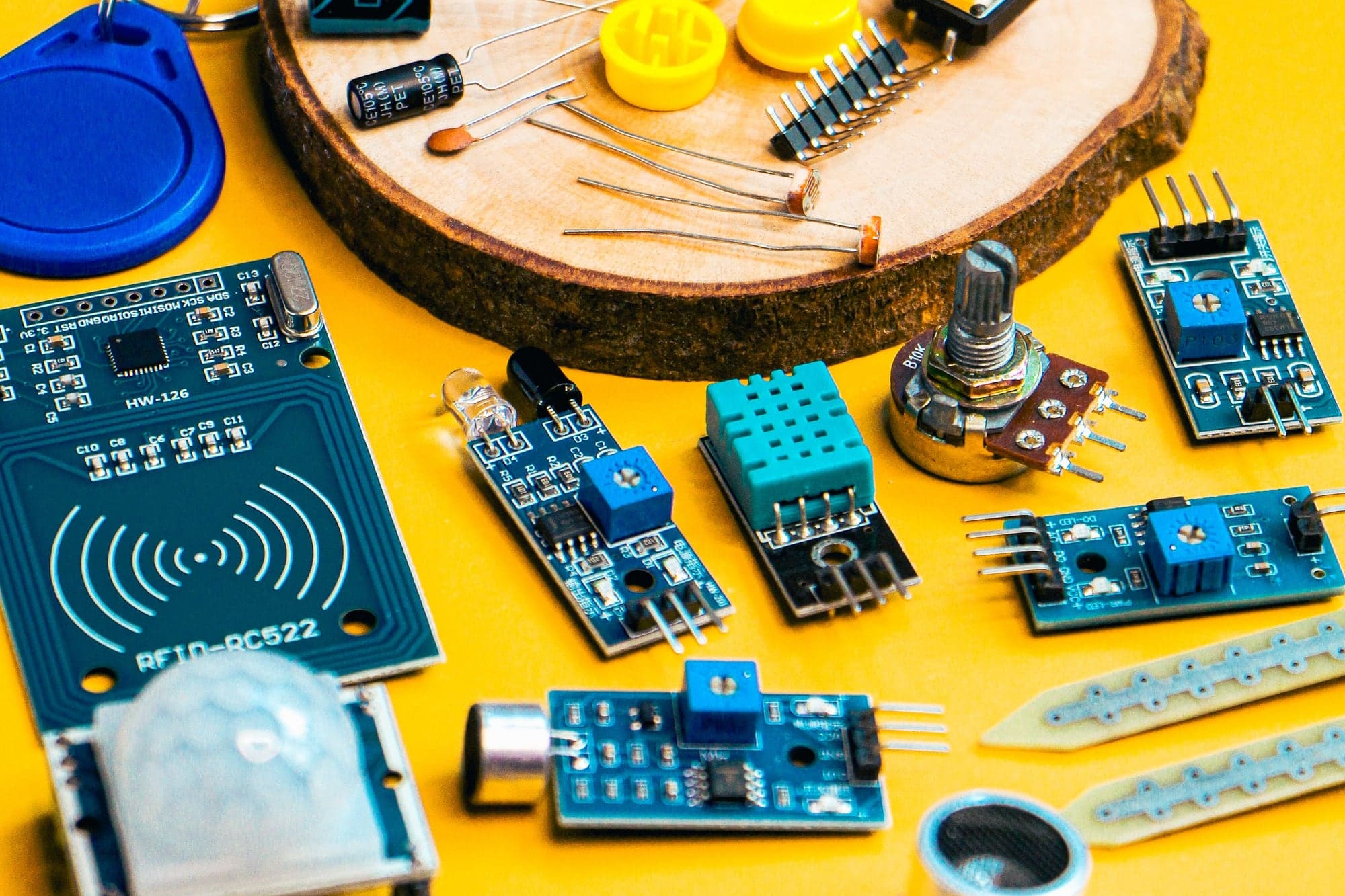 Sensor modules, an RFID reader and components laid out on a yellow table