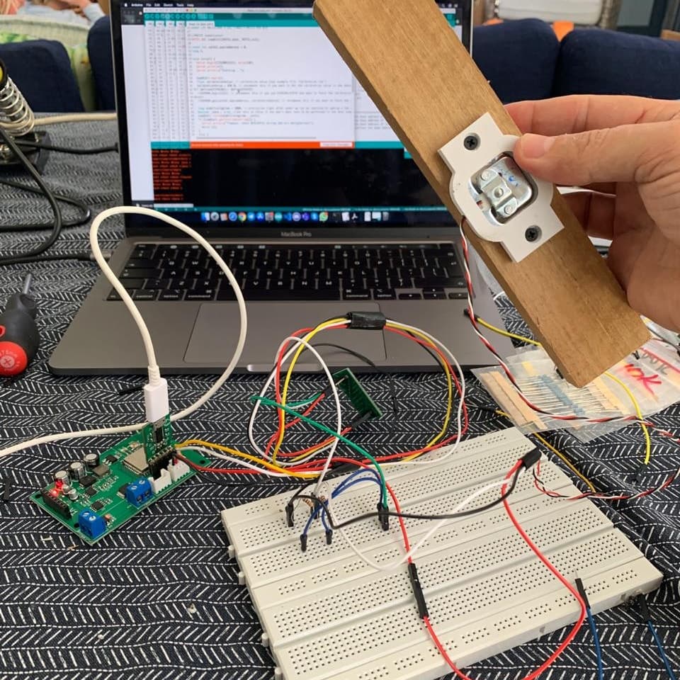 A load cell prototype on a breadboard, wired to a Handee controller board