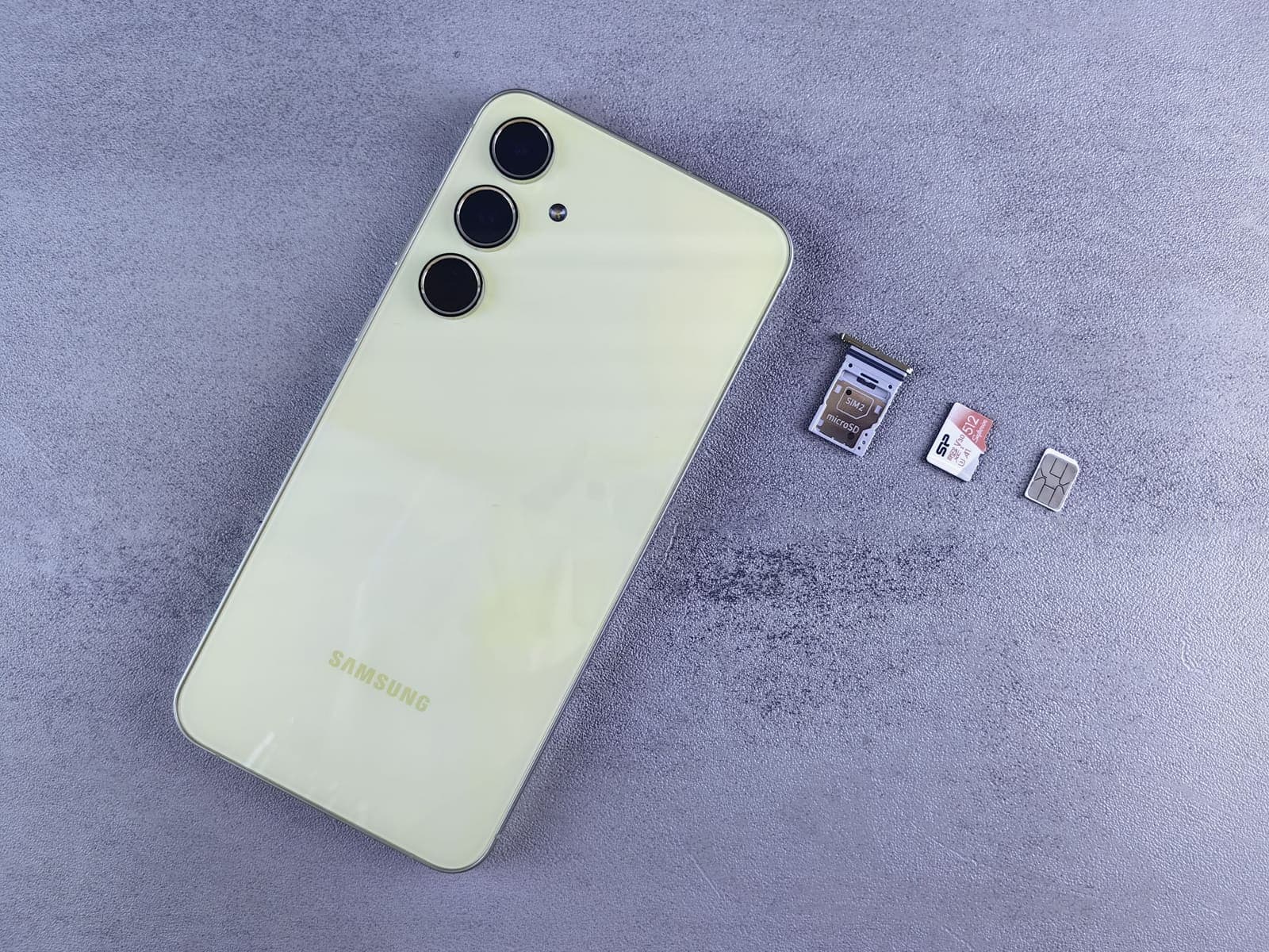 A smartphone, its SIM tray and loose SIM cards laid out on a pale surface