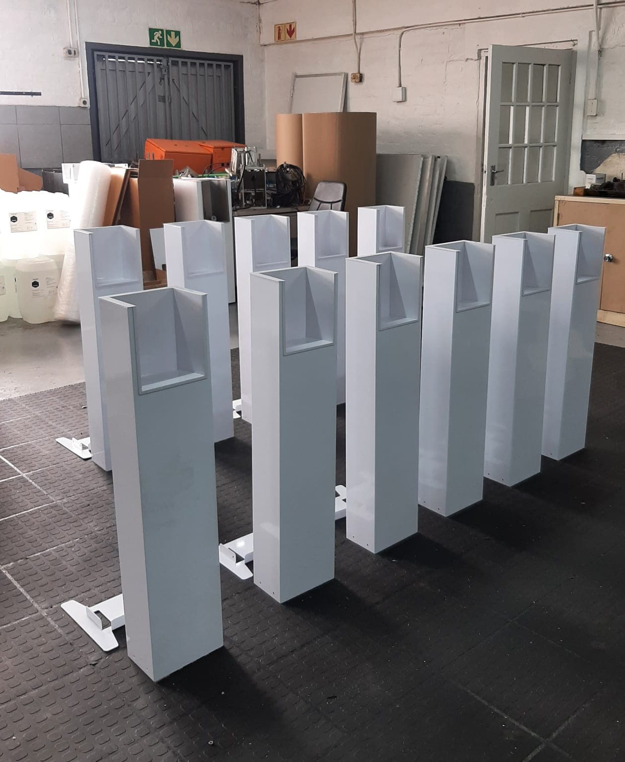 Handee sanitiser stands lined up in the workshop before assembly